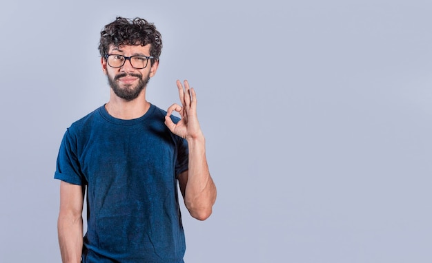 Homem bonito, gesticulando que está tudo bem Pessoa fazendo gesto okey Homem sorridente, mostrando o gesto okey olhando para a câmera a expressão de tudo está bem