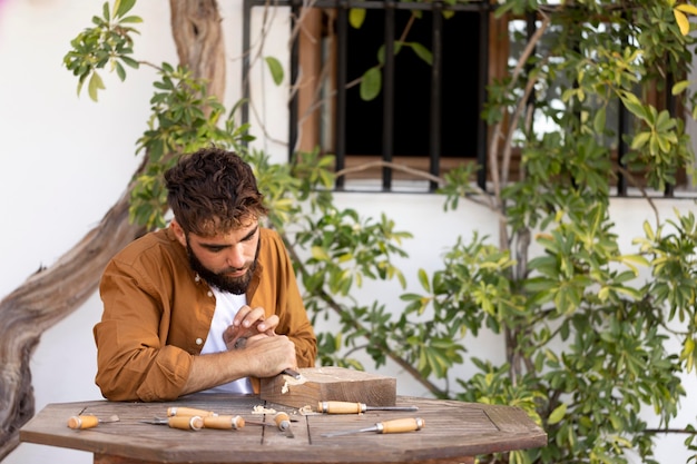 Foto homem bonito gravando em madeira ao ar livre