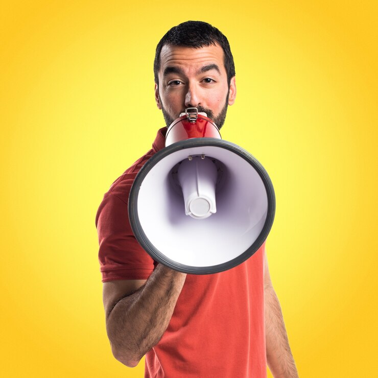 Foto homem bonito gritando por megafone em fundo colorido