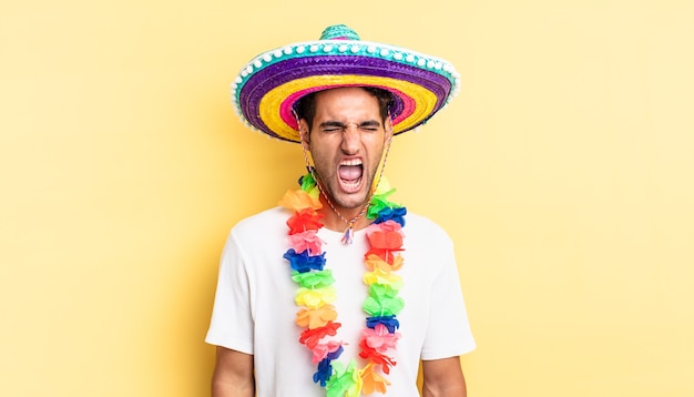 Homem bonito hispânico gritando agressivamente, parecendo muito zangado. conceito de festa mexicana