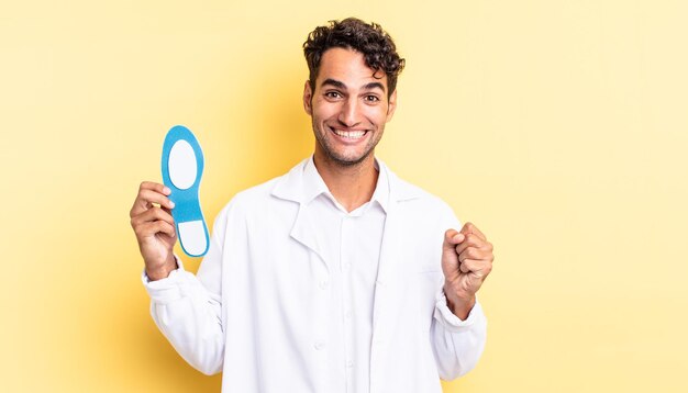 Homem bonito hispânico se sentindo chocado, rindo e comemorando o sucesso. conceito de quiropodista