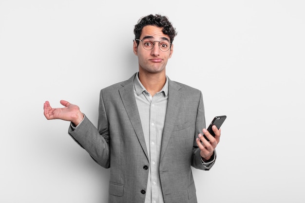 homem bonito hispânico se sentindo confuso e confuso e duvidando. conceito de negócios e telefone