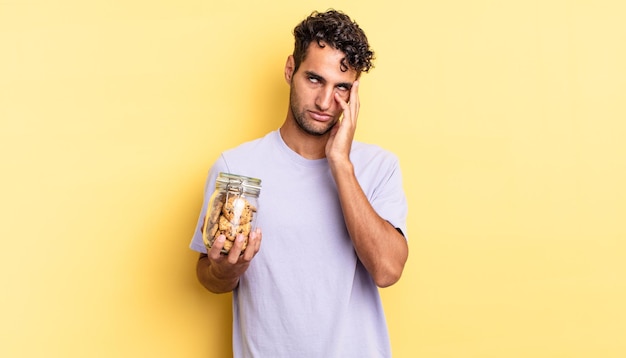 Homem bonito hispânico se sentindo entediado, frustrado e com sono depois de um cansativo. conceito de biscoitos