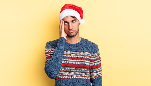 Homem bonito hispânico se sentindo entediado, frustrado e com sono depois de um cansativo. conceito de natal