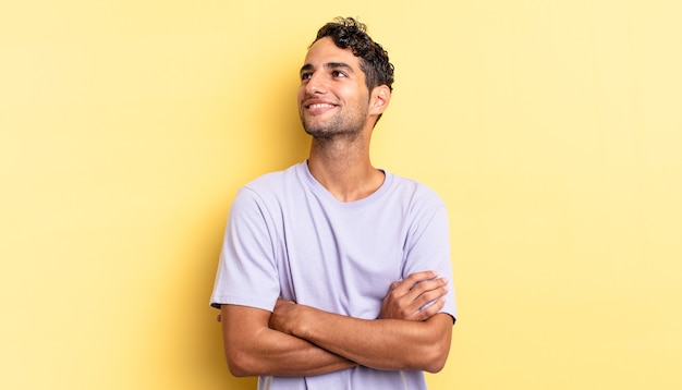 Homem bonito hispânico se sentindo feliz, orgulhoso e esperançoso, pensando ou pensando