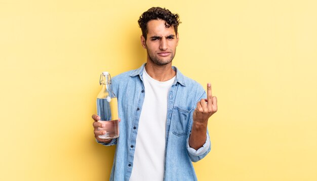 Homem bonito hispânico se sentindo irritado, irritado, rebelde e agressivo. conceito de garrafa de água