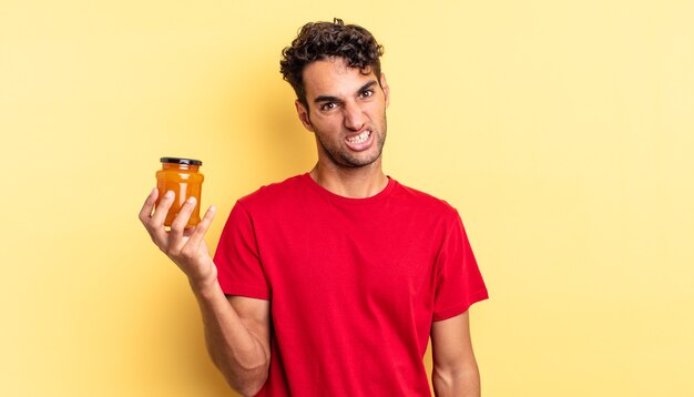 Homem bonito hispânico se sentindo perplexo e confuso. geléia de pêssego