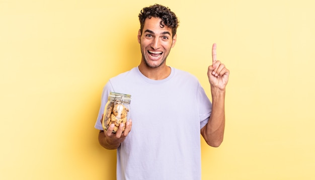 Homem bonito hispânico se sentindo um gênio feliz e animado depois de perceber uma ideia. conceito de biscoitos