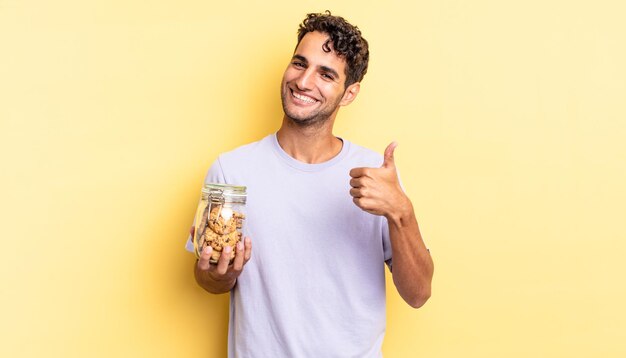 Homem bonito hispânico, sentindo-se orgulhoso, sorrindo positivamente com o polegar para cima. conceito de biscoitos