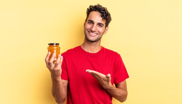 Homem bonito hispânico sorrindo alegremente, sentindo-se feliz e mostrando um conceito. geléia de pêssego