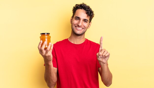 Homem bonito hispânico sorrindo com orgulho e confiança fazendo o número um. geléia de pêssego