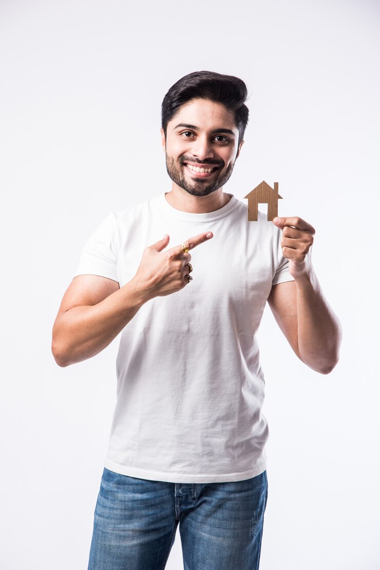 Foto homem bonito indiano segurando um modelo de casa em 3d feito de papel - conceito imobiliário