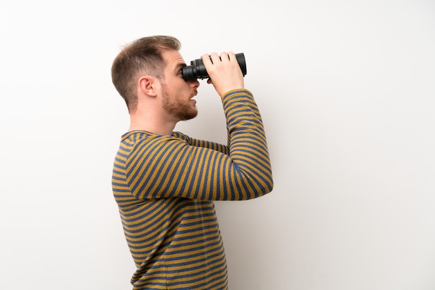 Foto homem bonito isolado parede branca com binóculos pretos