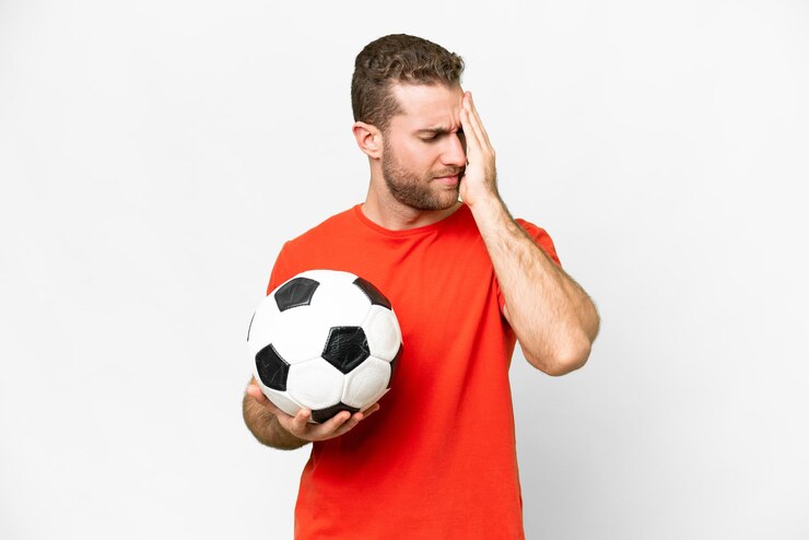 Foto homem bonito jovem jogador de futebol sobre fundo branco isolado com dor de cabeça
