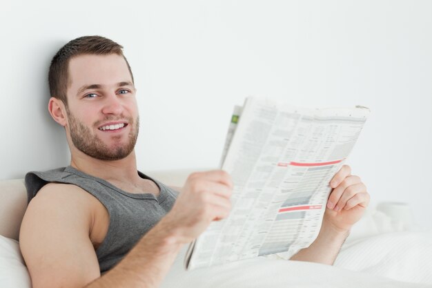 Homem bonito lendo um jornal