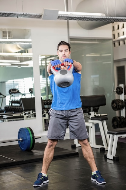 Homem bonito, levantando kettlebell