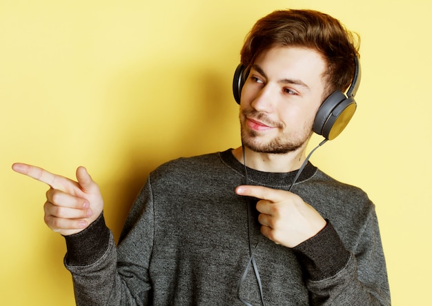 Homem bonito lictening a música sobre fundo amarelo