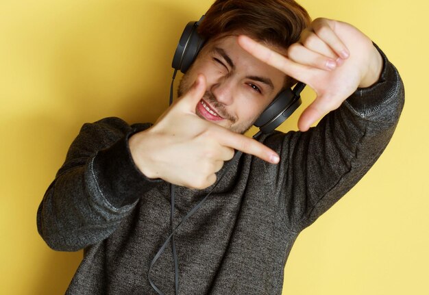 Homem bonito lictening a música sobre fundo amarelo