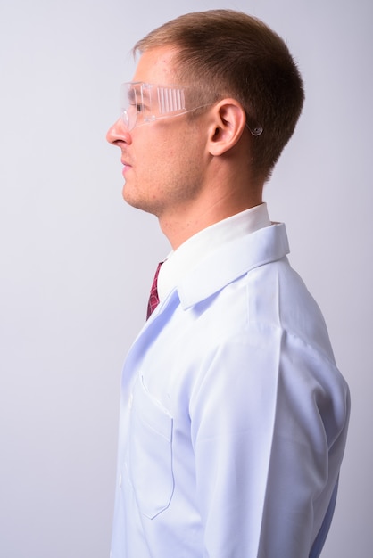 homem bonito médico como cientista usando óculos de proteção contra o espaço em branco