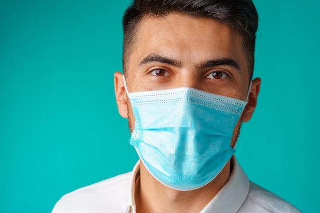 Homem bonito mestiço usando máscara médica