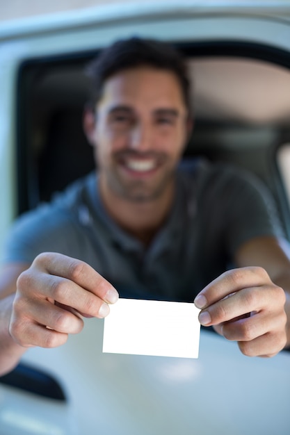 Foto homem bonito, mostrando o cartão de visita