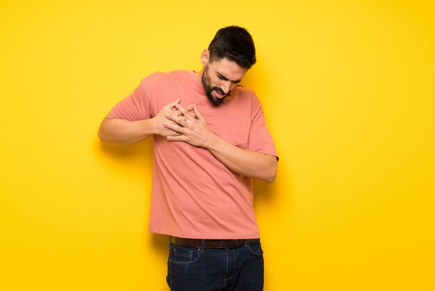 Homem bonito muro amarelo tendo uma dor no coração