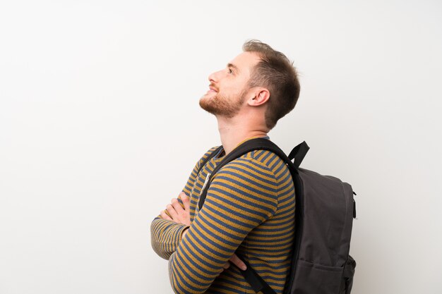 Homem bonito muro branco isolado com mochila