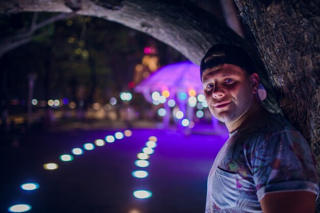 Homem bonito na iluminação de noite de fundo na Ásia