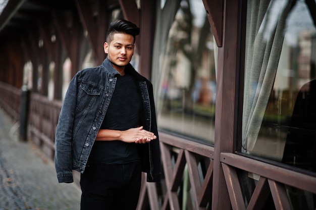 Homem bonito na jaqueta jeans preto posou ao ar livre