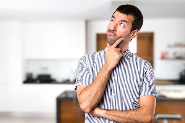 Homem bonito que pensa dentro da casa