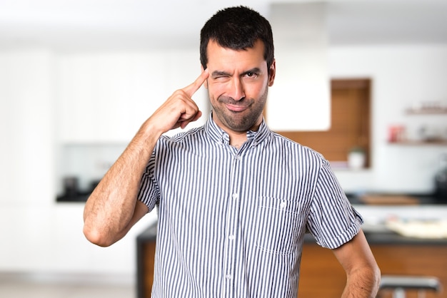 Foto homem bonito que pensa dentro da casa