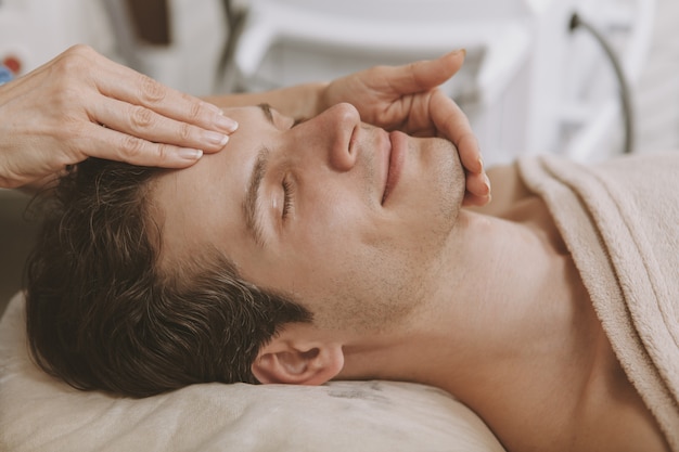 Homem bonito, recebendo tratamento de pele facial