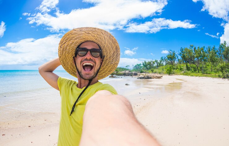 Foto homem bonito se divertindo tomando uma selfie na ilha tropical de férias