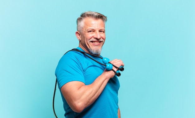 Homem bonito sênior praticando fitness e vestindo roupas esportivas