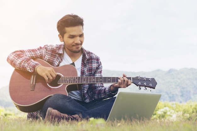 Homem bonito sorrindo, tocando violão