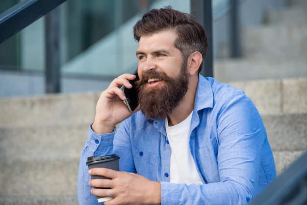 Homem bonito tem chamada de smartphone do lado de fora homem tem chamada de smartphone na rua