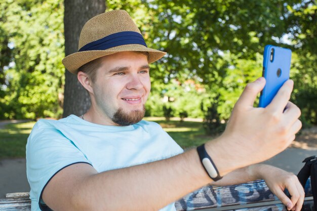 Homem bonito tirando selfie ao ar livre