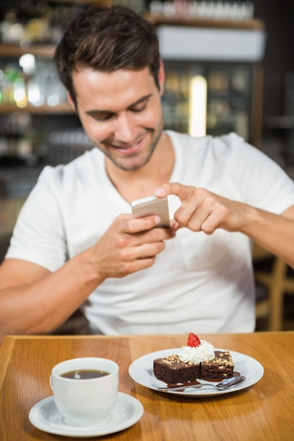 Homem bonito, tirando uma foto de sua comida