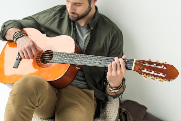 Homem bonito tocando violão