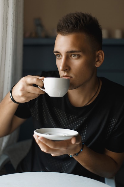 Foto homem bonito tomando café dentro de casa