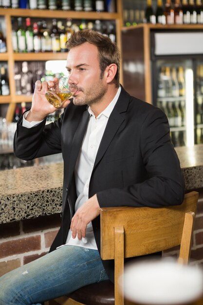 Homem bonito, tomando um uísque