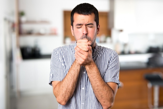 Homem bonito tossindo muito dentro da casa