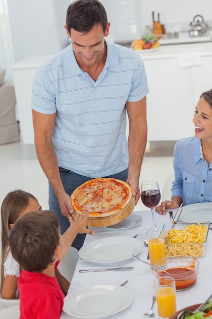 Homem bonito, trazendo uma pizza para sua família