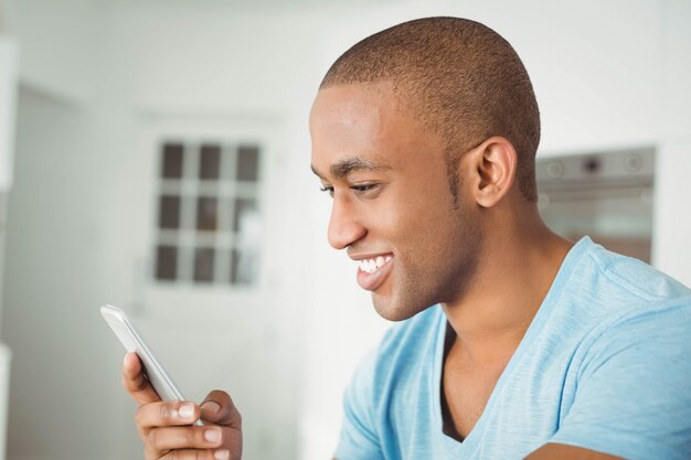 Homem bonito usando smartphone em casa