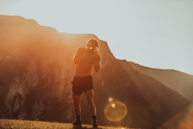 Homem boxe com sombra exercitando ao pôr do sol ao ar livre Conceito de estilo de vida saudável da vitória do Porto Homem sombra boxe pequeno campeão boxer silhueta sol