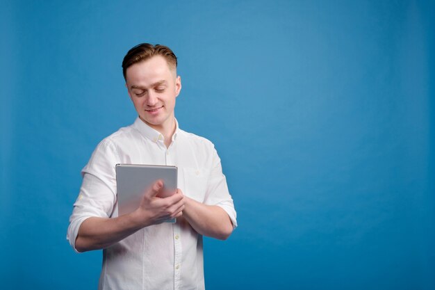 Homem branco bonito vestindo camisa branca usar tablet,