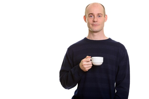 Homem branco careca segurando uma xícara de café e olhando para a câmera