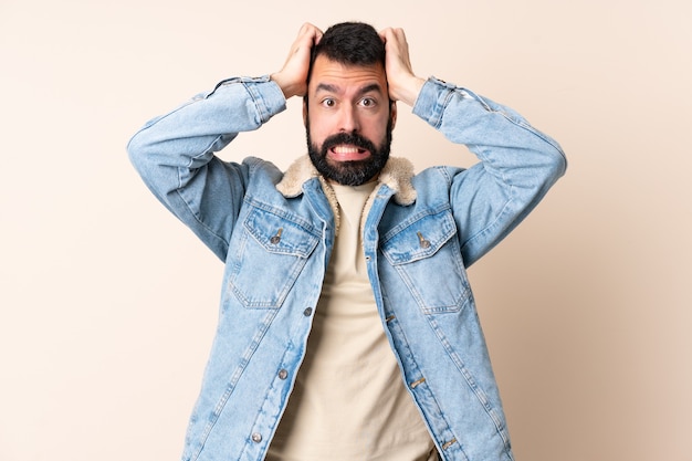 Homem branco com barba sobre parede isolada fazendo gesto de nervosismo