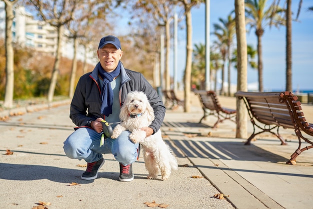 Foto homem branco pequeno cão para passear no parque