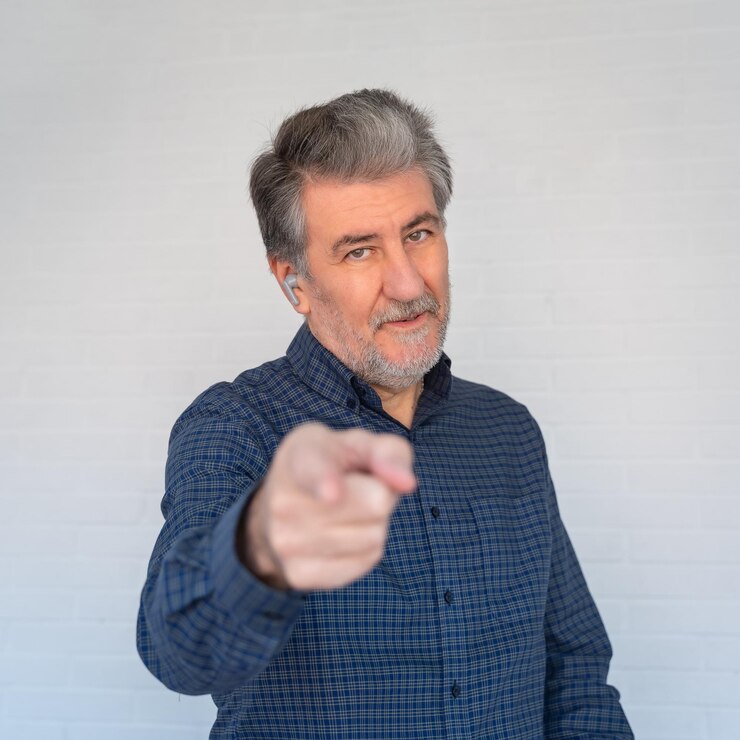 Foto homem branco sênior apontando para a câmera com o dedo indicador com atitude positiva